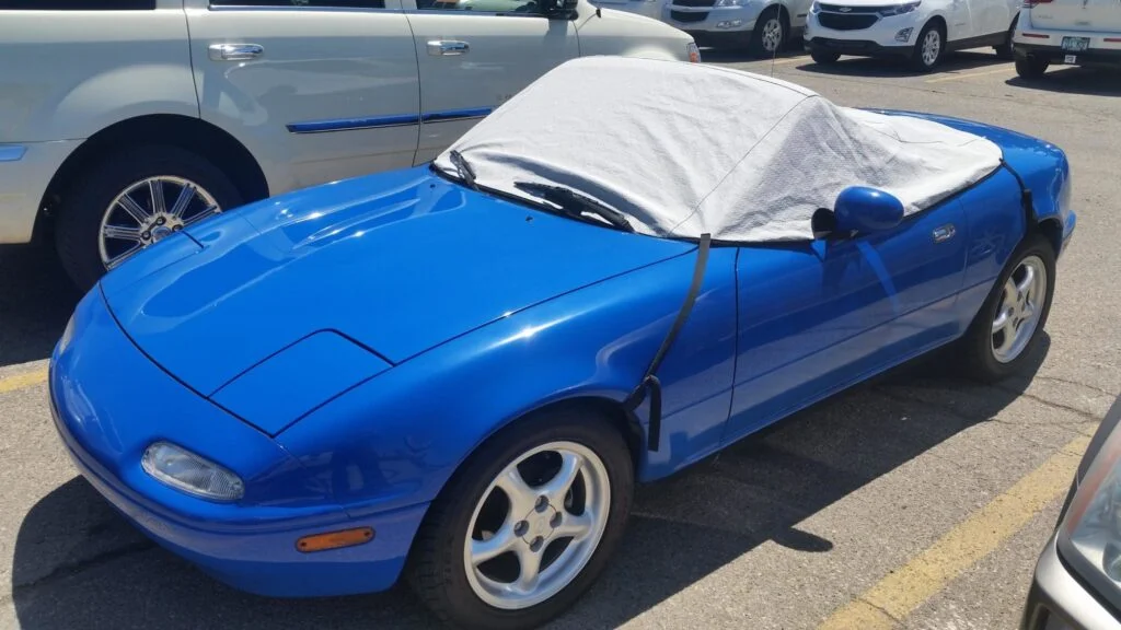 A Mazda Miata with soft top cover