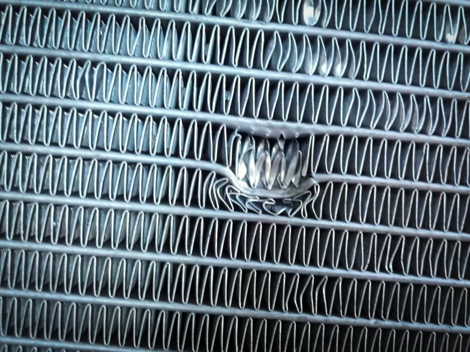 Radiator with a hole and bent fins