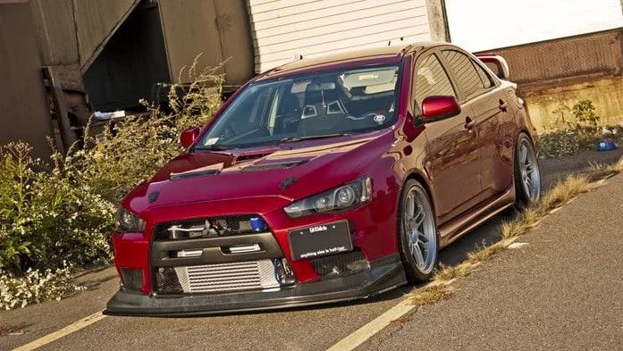 Voltex carbon front splitter on modified red Mitsubishi Evo X