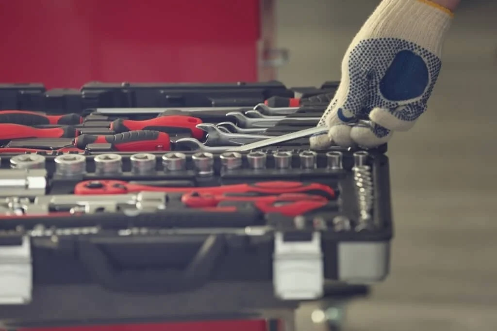 Auto Mechanic Picking up Tools From His Set
