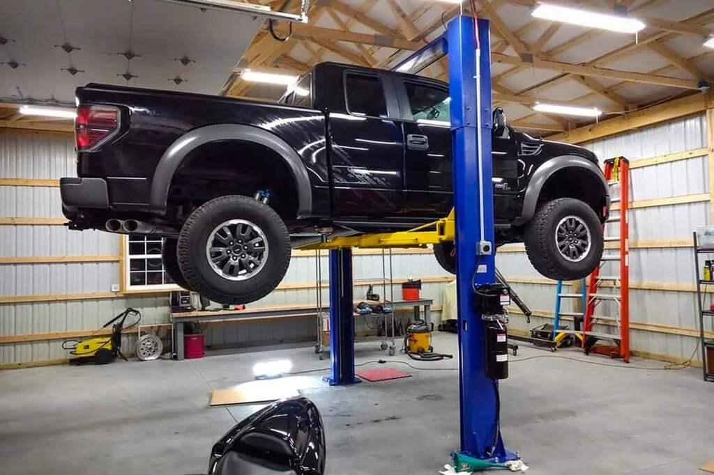 Heavy Ford F150 Raptor pickup truck on a 2 post lift