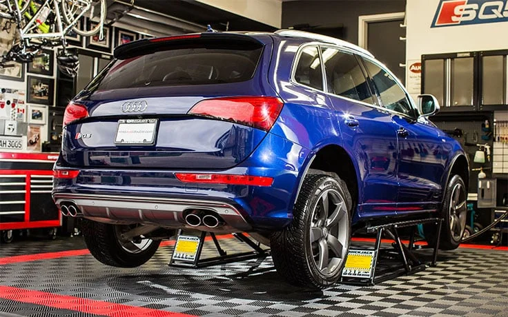 Audi SQ5 on a portable lift in a home garage