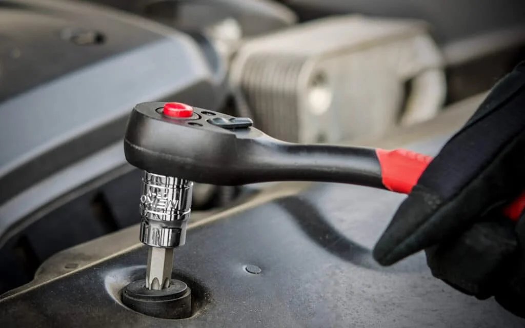 DIY home mechanic using Torx bit and socket wrench