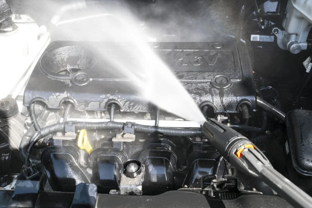 Unsafe spraying of water at the engine using a high pressure hose.