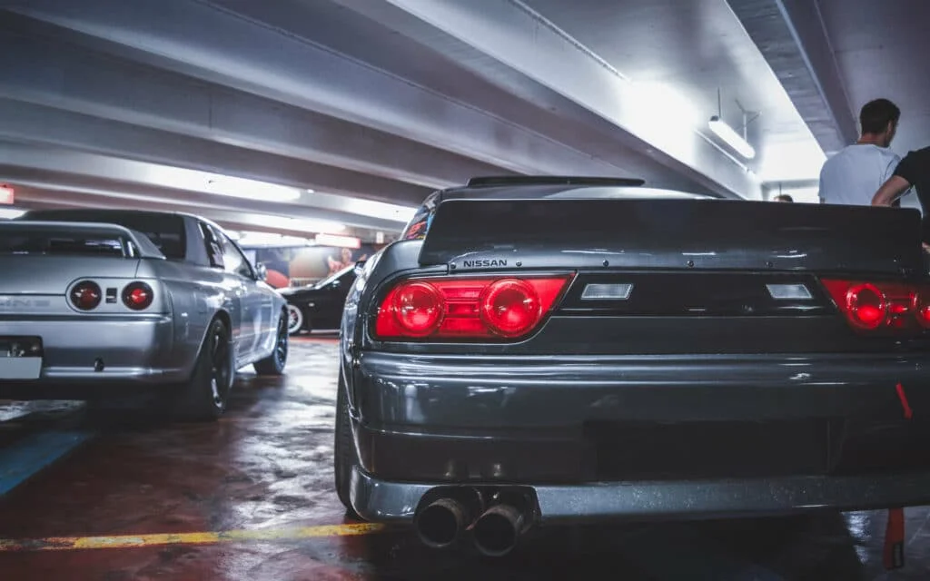 Two JDM cars: Nissan 180SX (S13) and a Nissan Skyline (R32)