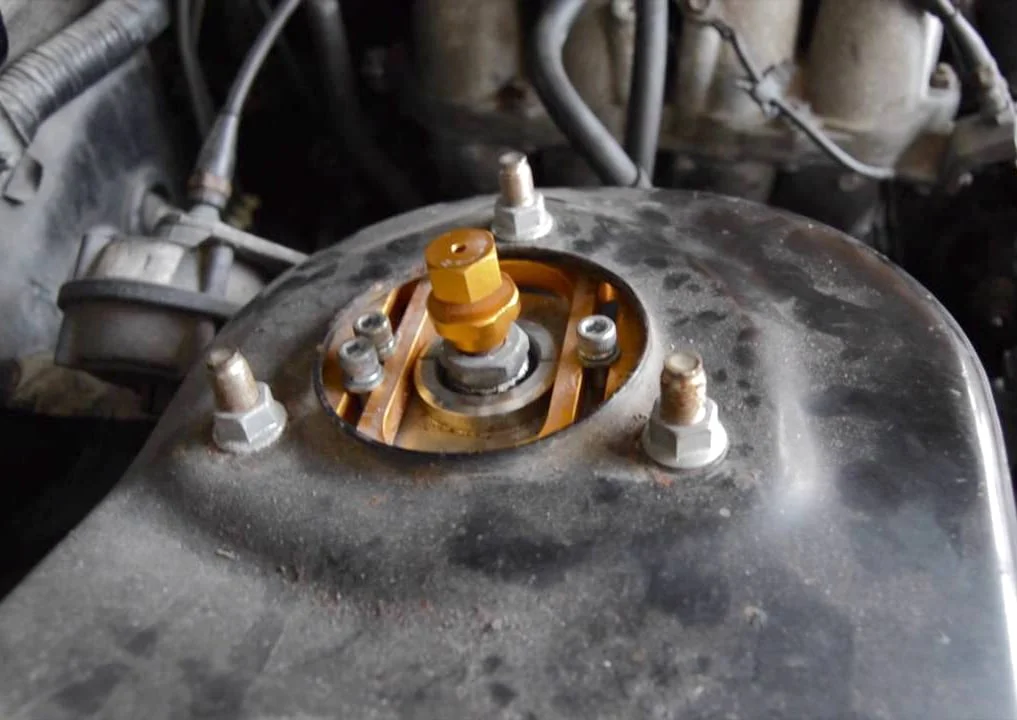 Camber adjustment via strut top