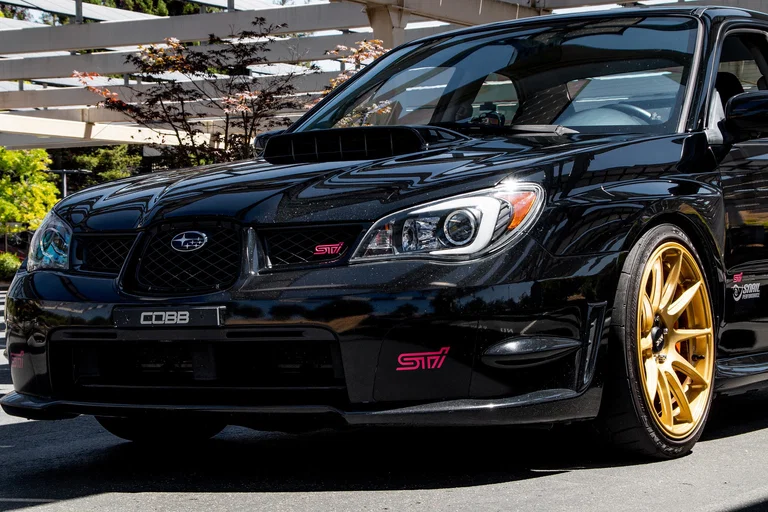 Black Subaru WRX STI with gold wheels