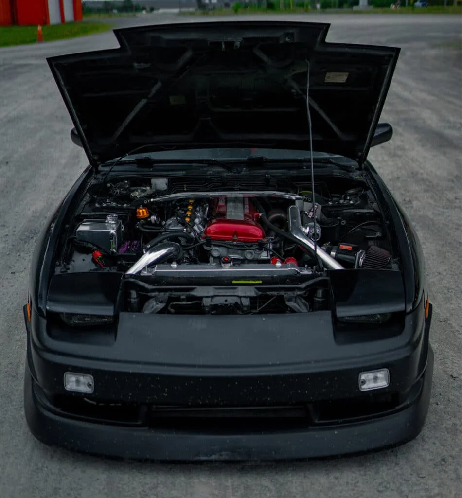 A modified black 240SX with its hood open