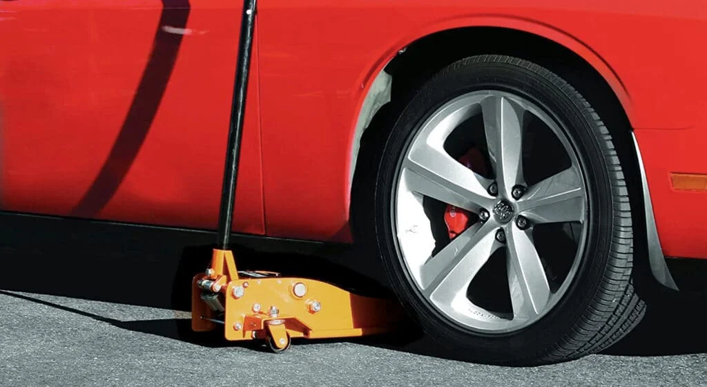 Floor jack placed under a car
