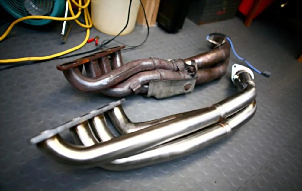 Old rusted headers next to new shiny headers