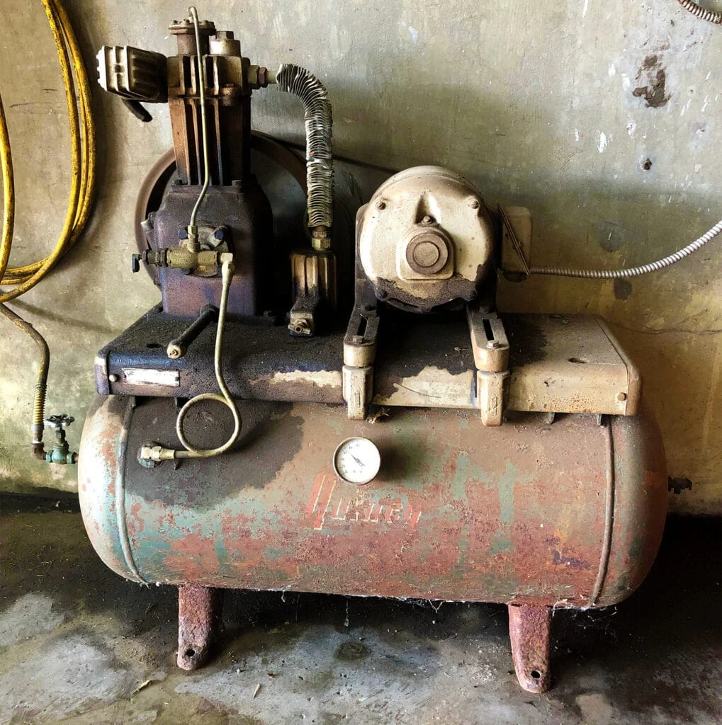 An old, heavy-duty shop air compressor