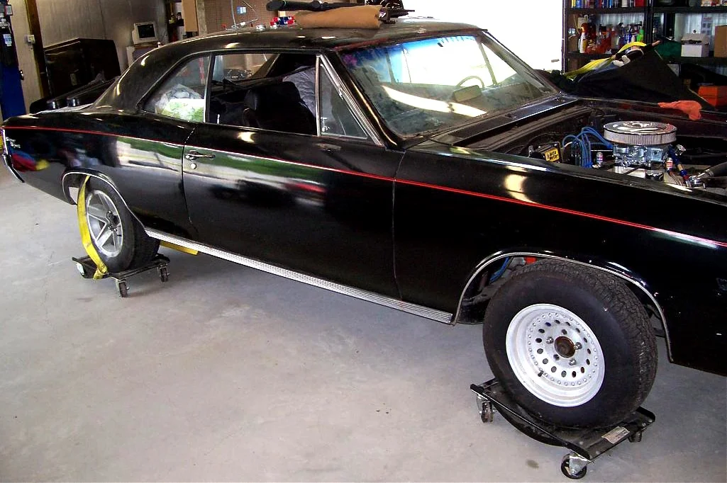Muscle car on skate-type wheel dollies