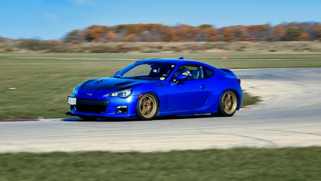 Blue BRZ with gold RPF1 rims at a track
