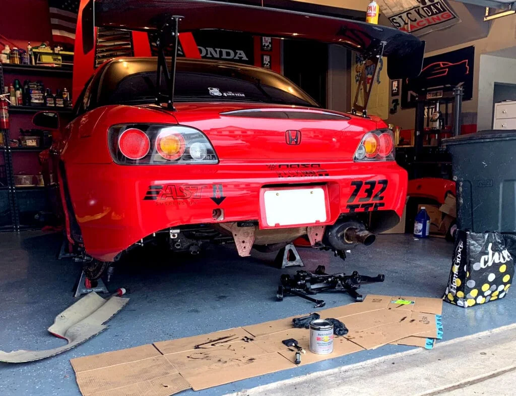 A red Honda S2000 being corner balanced.