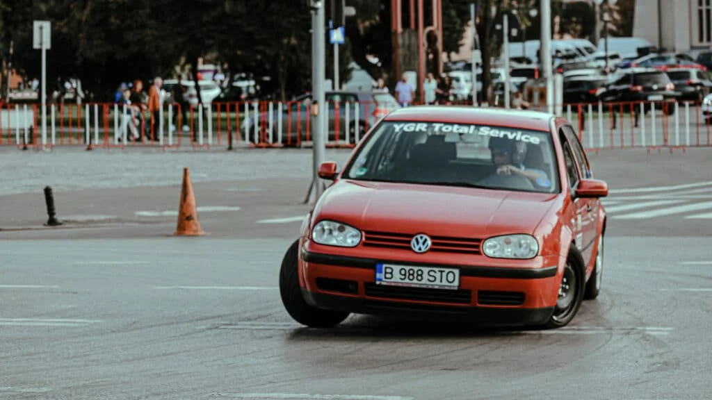 An orange Volkswagen Jetta banking hard into a corner 
