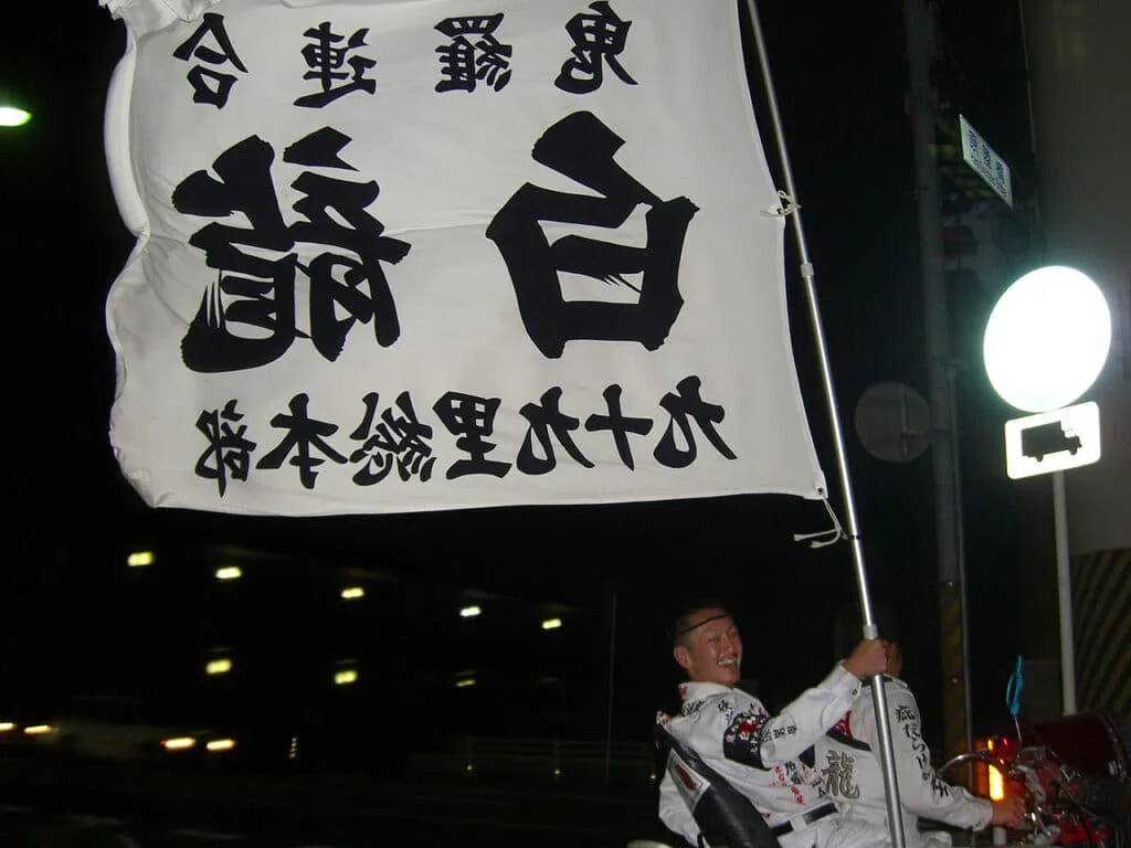 Japanese biker gang member waving Kanji slogan