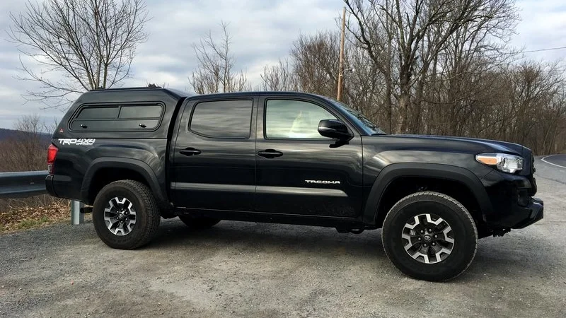 Leer 180XL camper shell installed on a black Tacoma