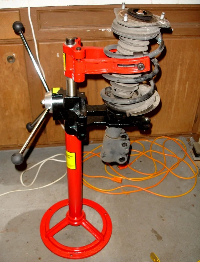 A floor mounted spring compressor in use