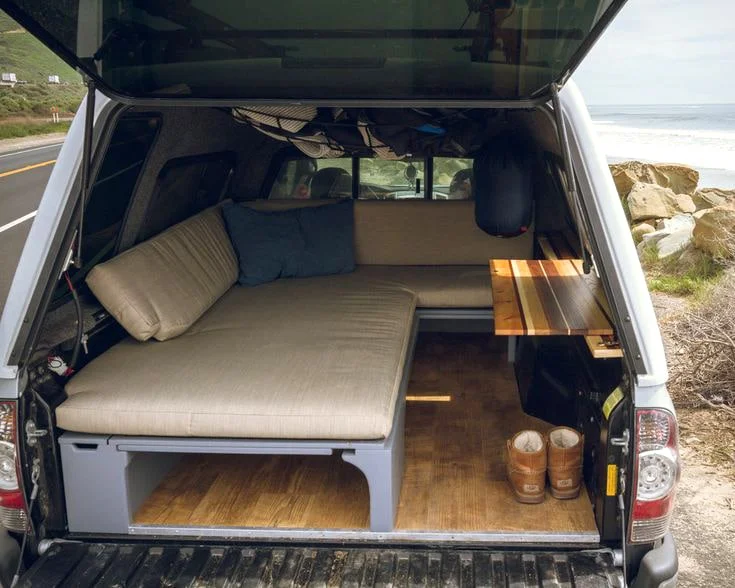 Makeshift bedroom inside camper-shell fitted Tacoma