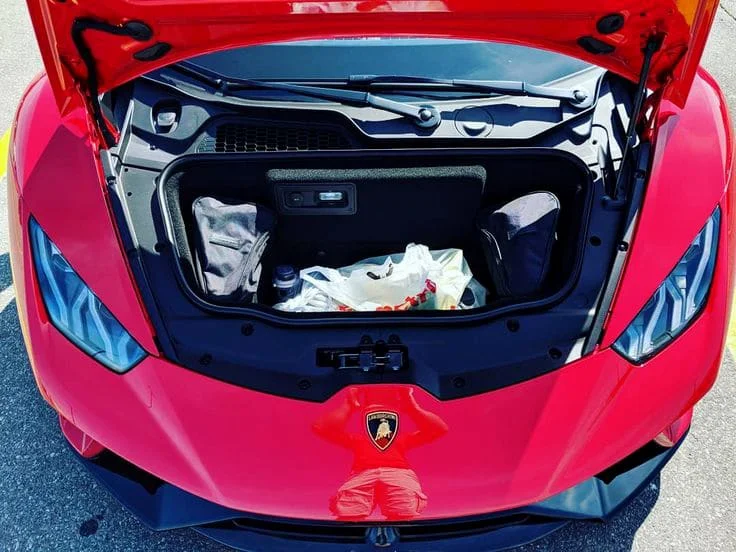 Groceries in the front trunk of a red Lamborghini Huracan