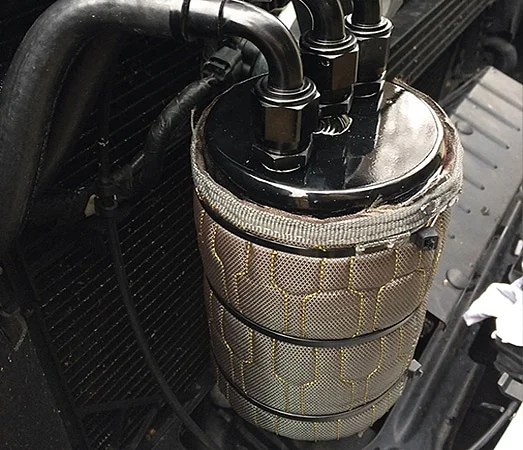 Oil catch can covered with insulated sleeve
