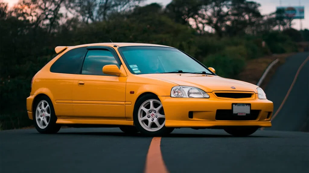 A clean, yellow Honda Civic EK9 on coilovers