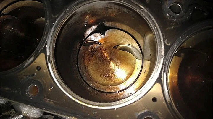 Piston damage due to engine knock, causing low compression pressure