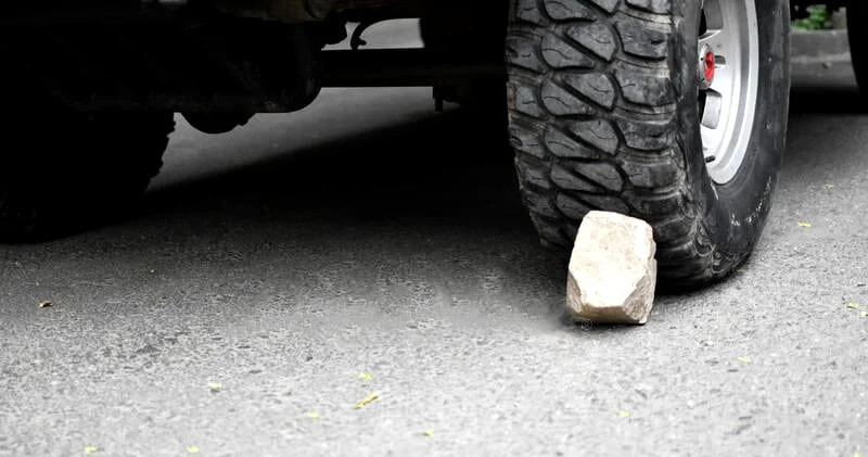 An SUV chocked using a rock