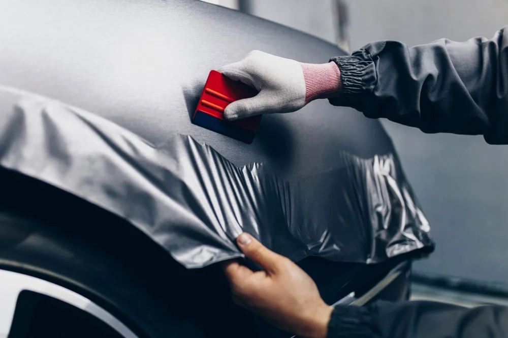 Working car wrap vinyl in with a squeege