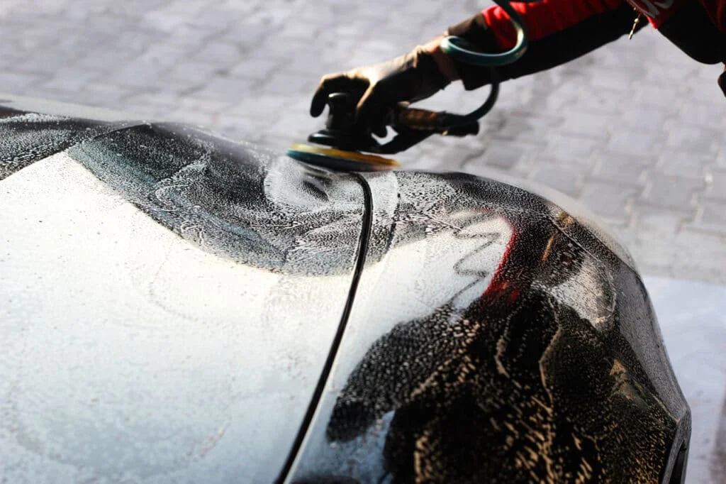 A black sedan being polished by a professional