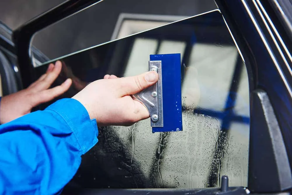 A professional applying window tint