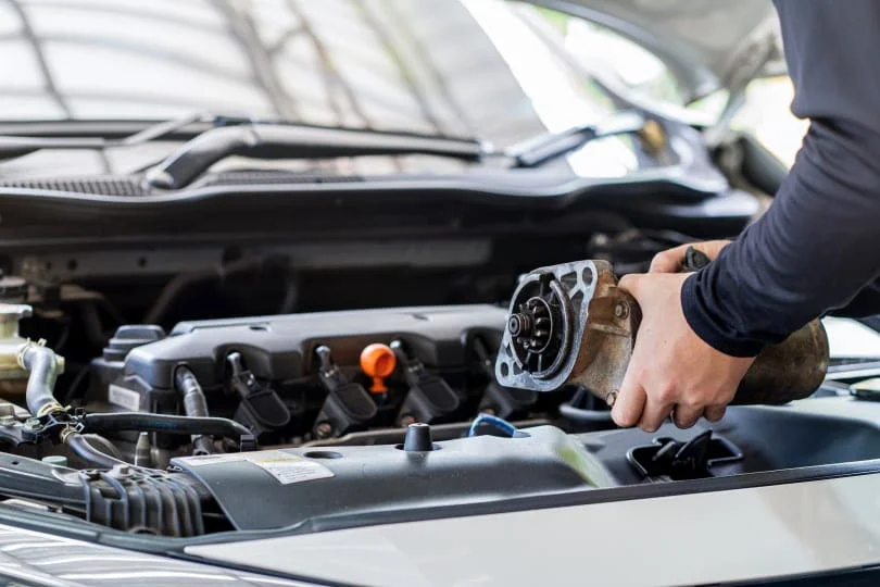 Technician replacing a faulty starter