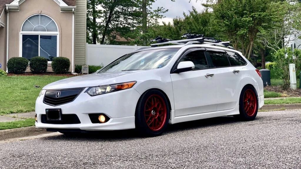 A white 2014 Acura TSX Sport Wagon with anodized red rims