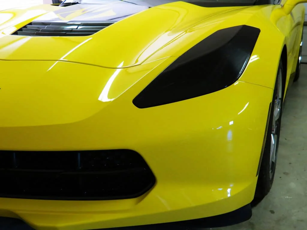 Blacked out headlights on a yellow Corvette