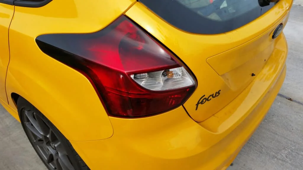Yellow Ford Focus with moderately tinted tail lights
