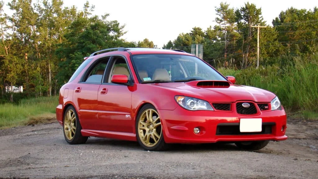 A red Impreza WRX wagon with gold rims
