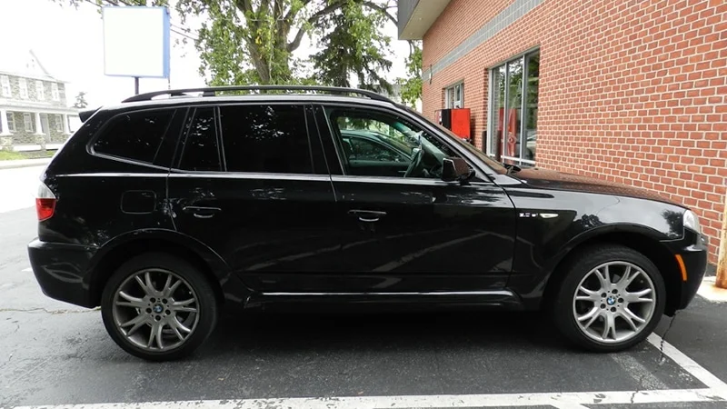 Black BMW SUV with dark black window tint