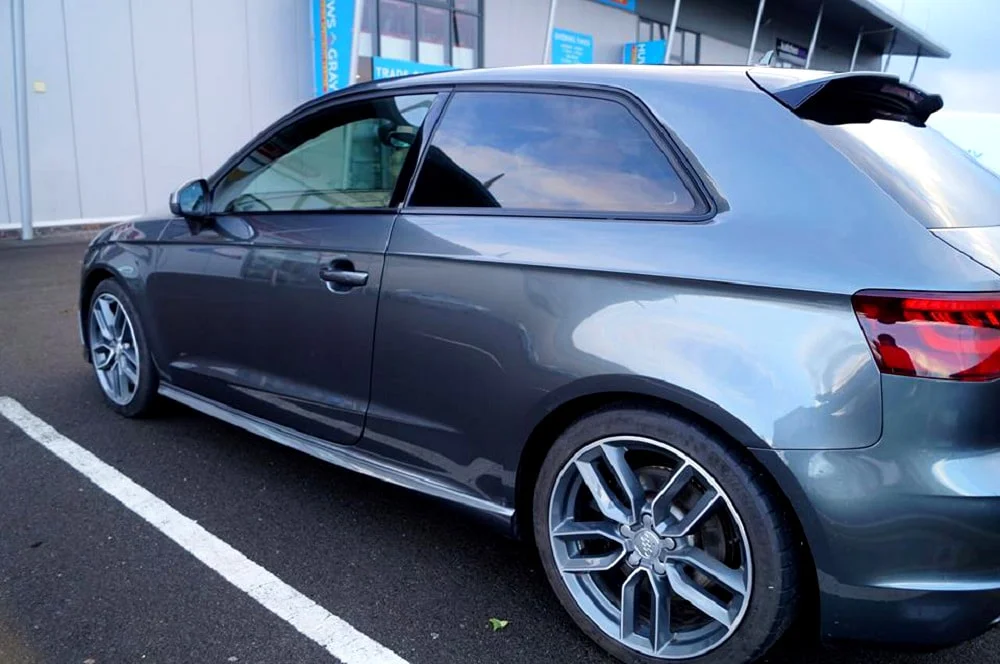 Silver Audi crossover with reflective tinted windows.