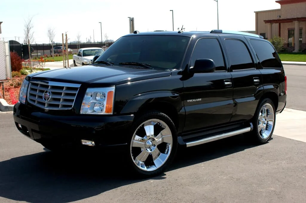 Clean black Cadillac Escalade with dark tint.