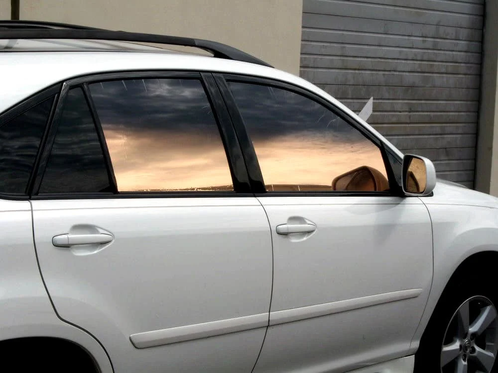 Bronze reflective window tint on white sedan