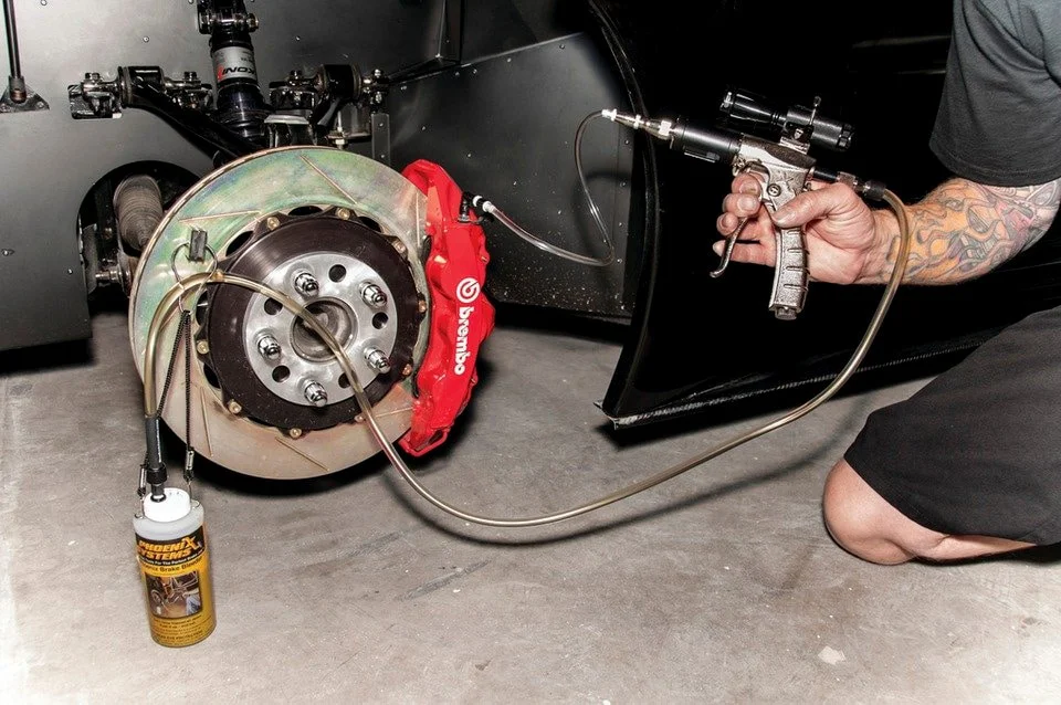 Vacuum bleeder attached to red Brembo caliper