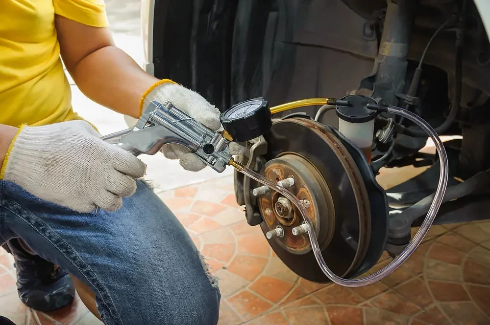 Vacuum-operated bleeder attached to brake caliper