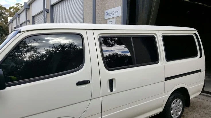 White minivan with dark black reflective tint in New Hampshire