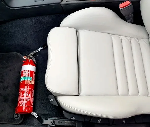 An extinguisher bottle mounted in the interior of a car
