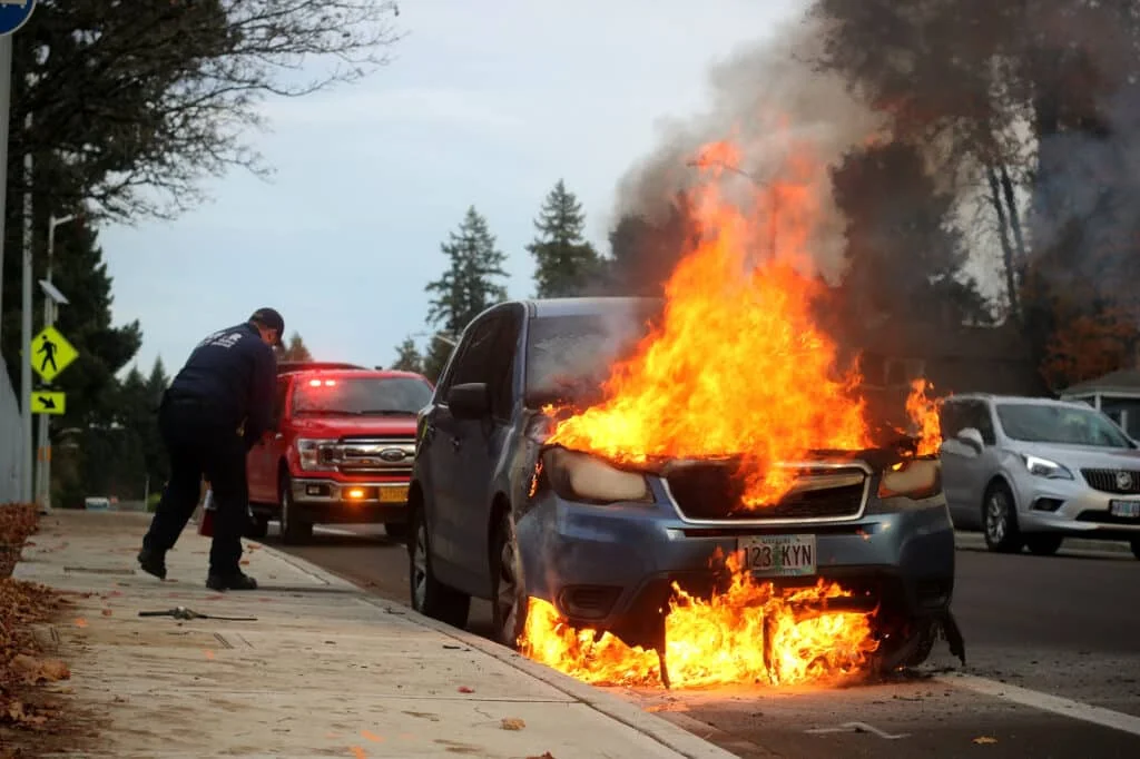 A blue hatchback on fire