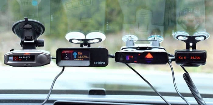 Multiple radar detectors mounted on the windshield of a car