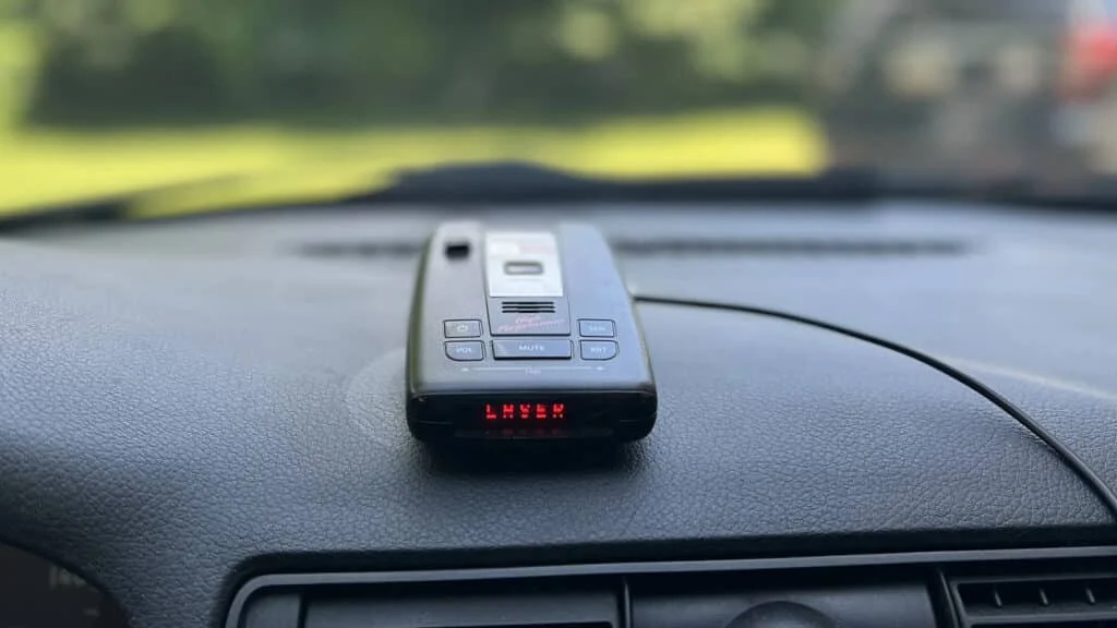 Small radar detector mounted on dashboard