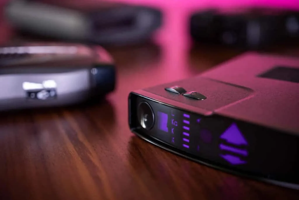 Black radar detector placed on a table under flouroscent light