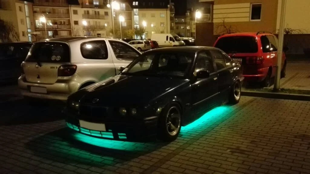 Black BMW sedan with green underglow