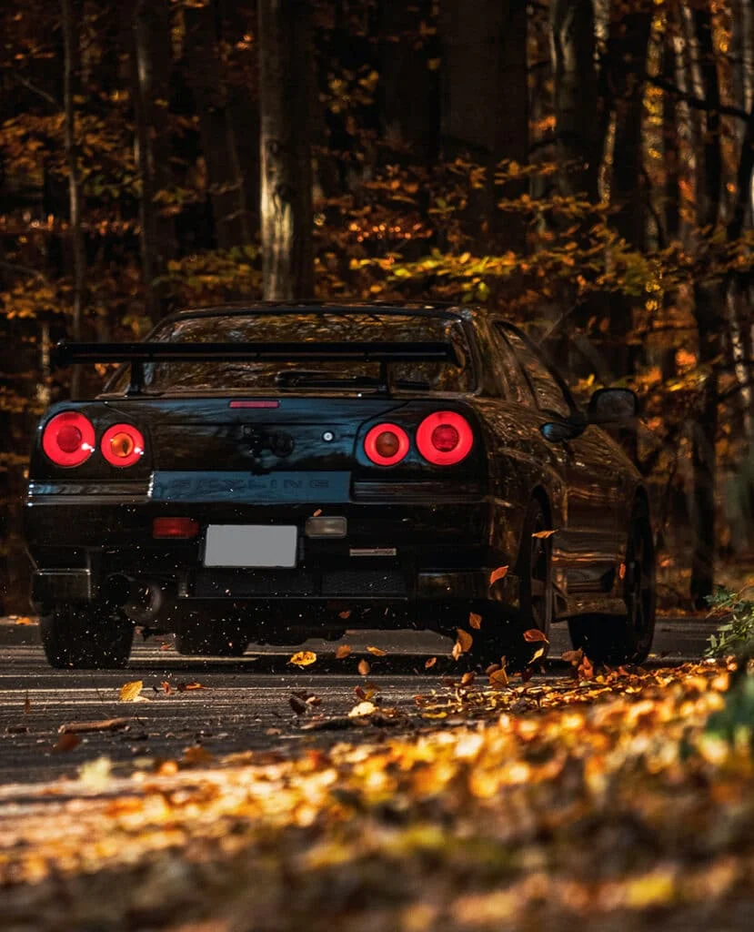 Black R34 Skyline driving through a Japanese mountain pass